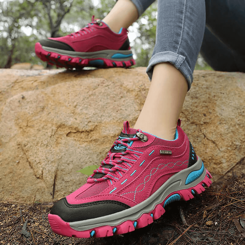 Woman hiking in pink Trekking Women's Sneakers with lace-up, offering comfort and support for outdoor adventures.